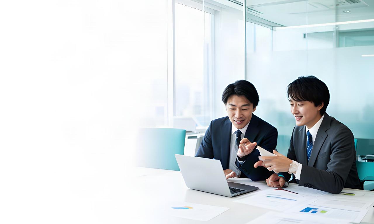 有明の明るいオフィスで、担当者が業務データを見ながら改善案を話し合う様子